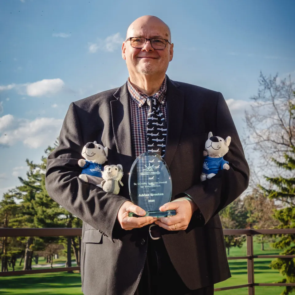 Adrian Brookes smiling and holding award.