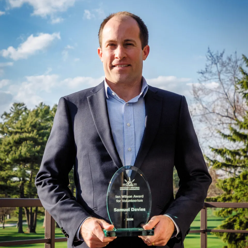 Sam Davies holding award and smiling.