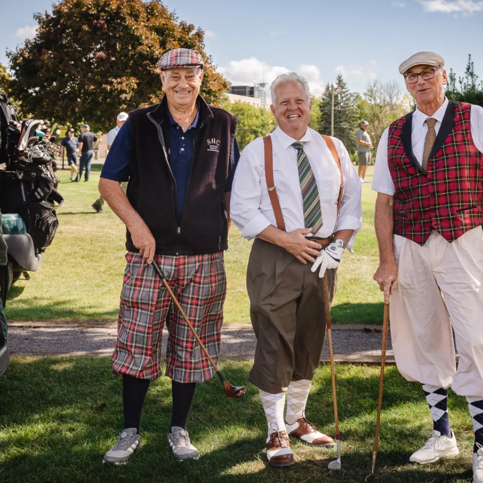 Three male golfers wearing classic tartan gear.