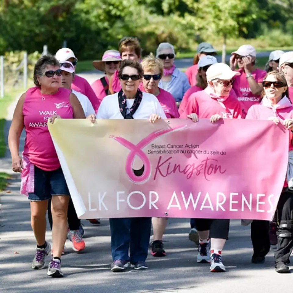 2025 Walk for Awareness. Female walkers dressed in pink holding BCAK banner.