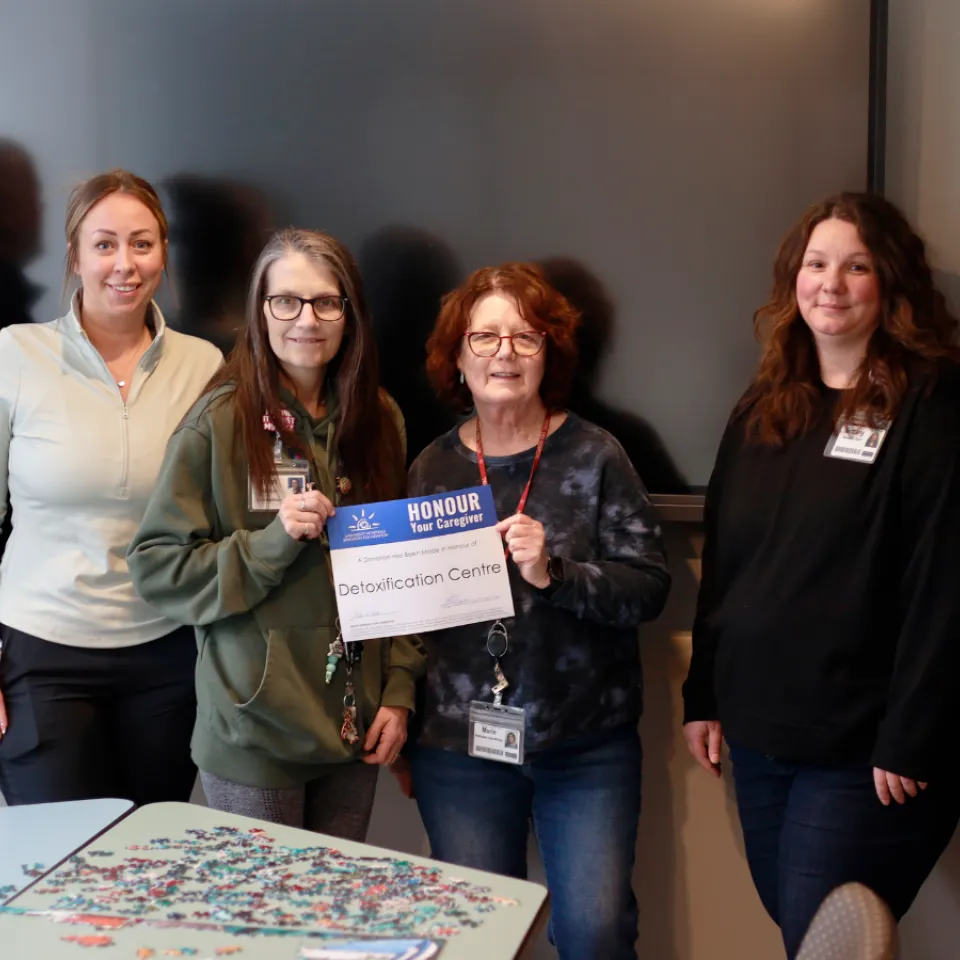 Detox Centre team smiling and holding and Honour Your Caregiver certificiate.