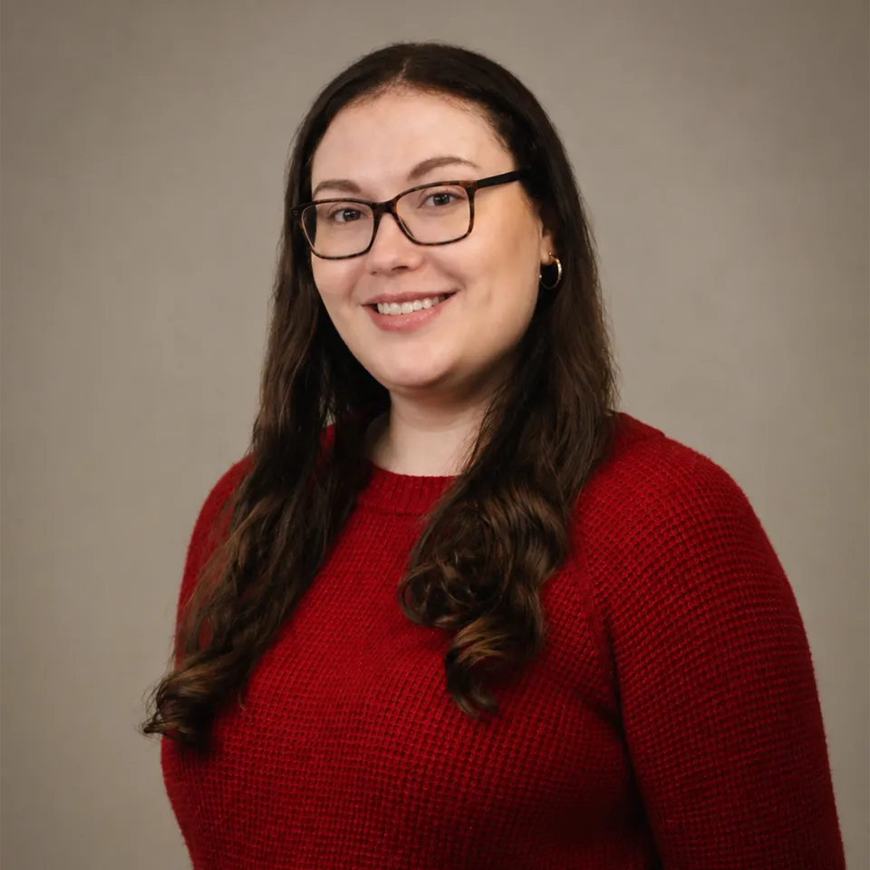 Saige Clark headshot. She's wearing a red sweater.